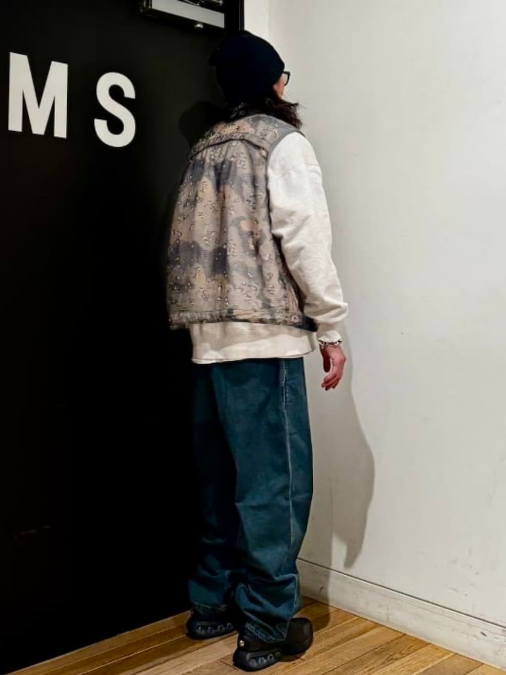 ブルー系のデニムパンツ、ブラック系のスニーカー、グレー系のスウェットを着用したメンズの春コーディネートの2枚目の写真