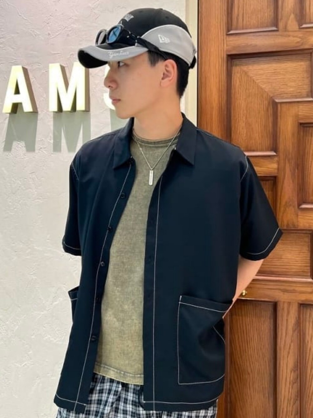 ブラック系のカーゴパンツ、ブラック系のシャツ/ブラウス、イエロー系のTシャツ/カットソーを着用したメンズの夏コーディネートの2枚目の写真
