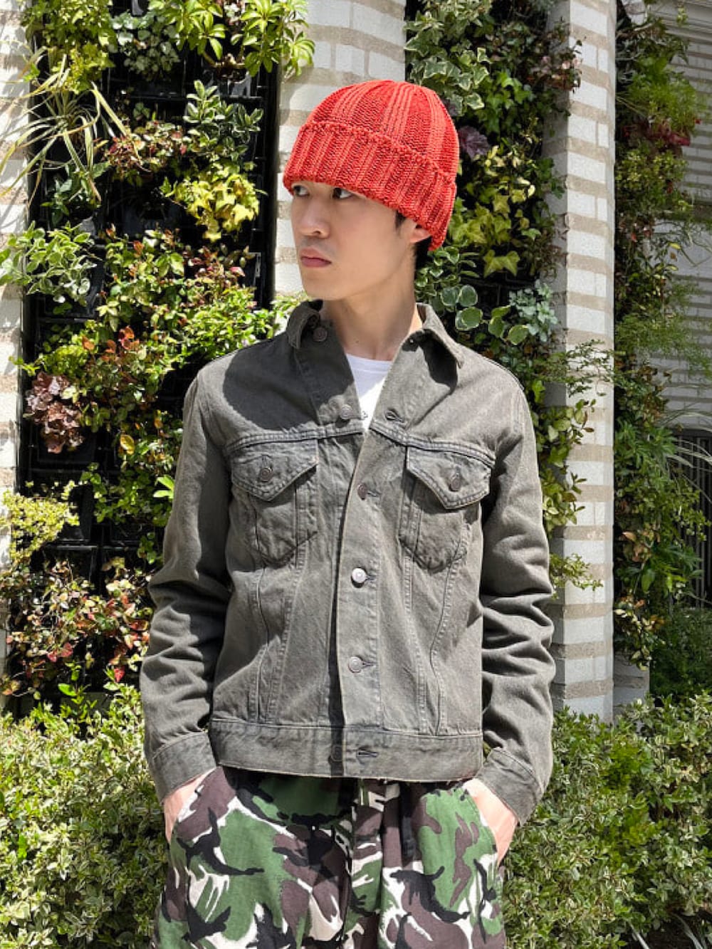 グレー系のデニムジャケット、グリーン系のカーゴパンツを着用したメンズの春コーディネートの3枚目の写真