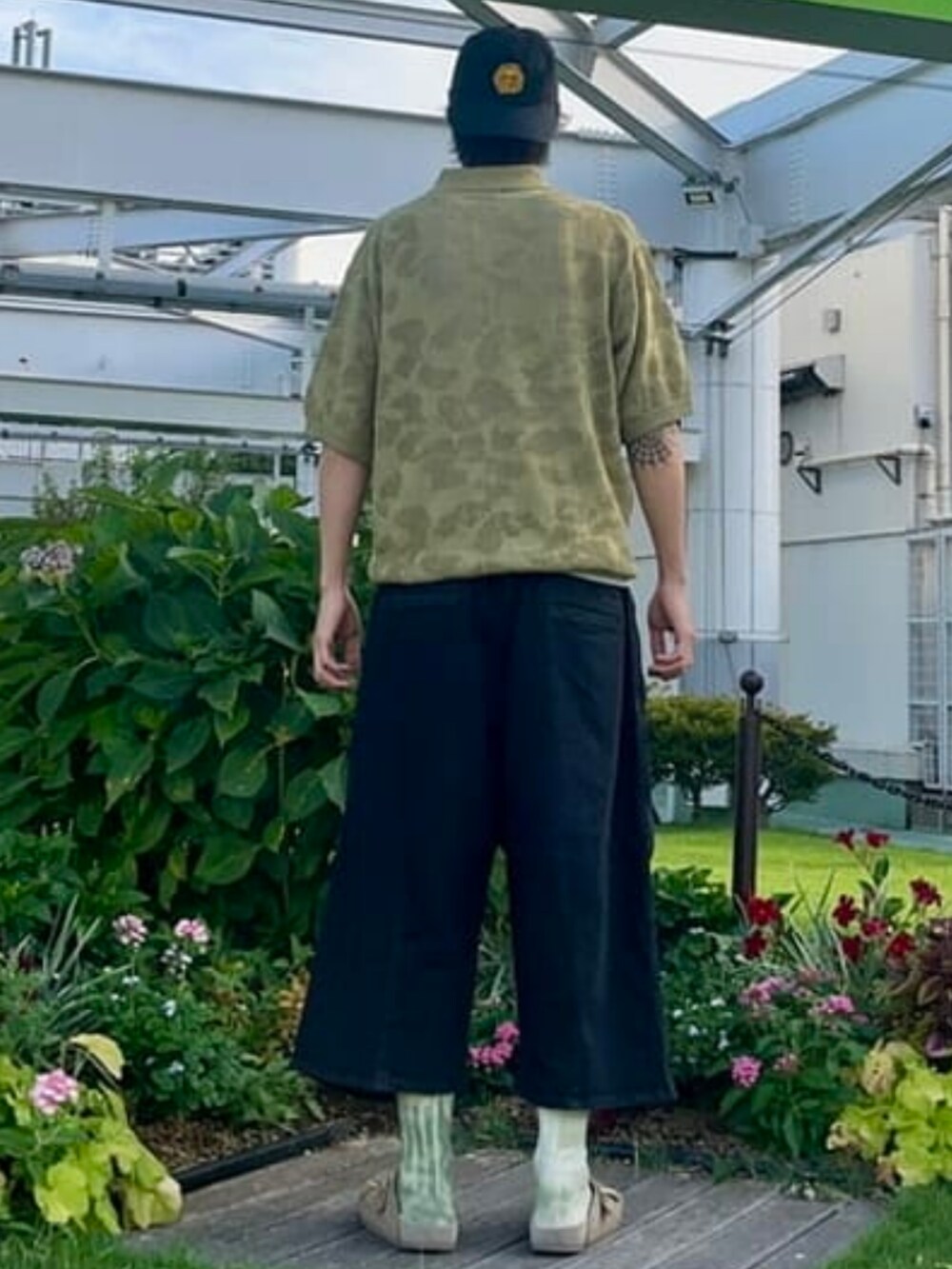 ブラック系のその他パンツ、グリーン系のポロシャツを着用したメンズの夏コーディネートの2枚目の写真