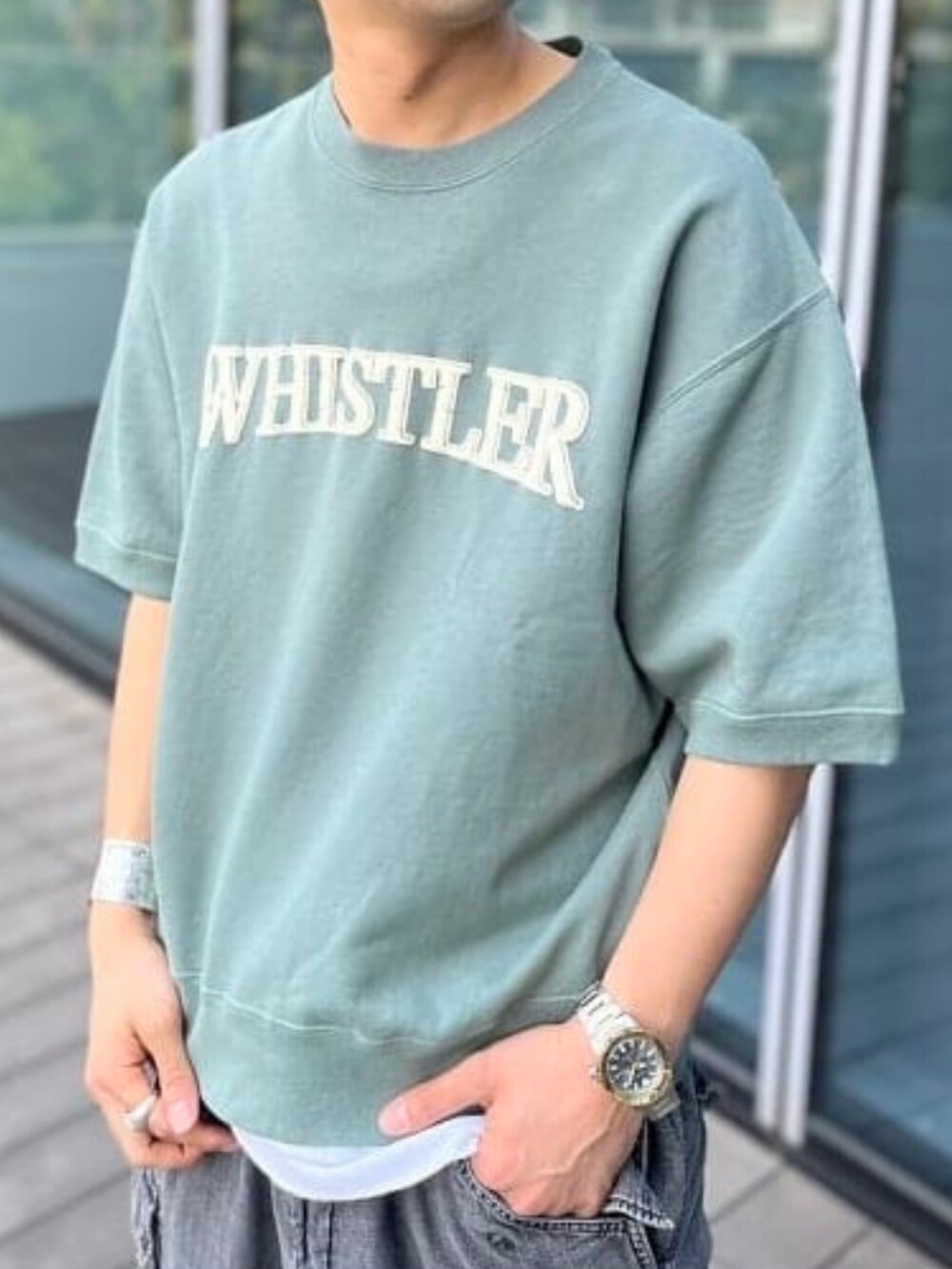 グリーン系のスウェット、ブラック系のカーゴパンツを着用したメンズの夏コーディネートの2枚目の写真