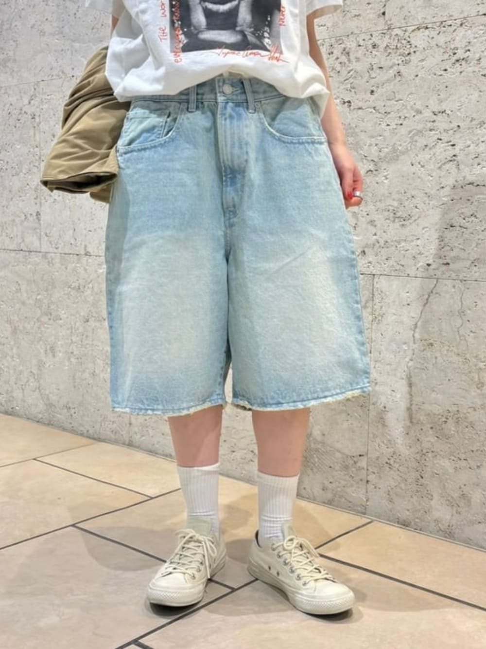 ブルー系のデニムパンツ、ベージュ系のブルゾンを着用したレディースの春コーディネートの2枚目の写真
