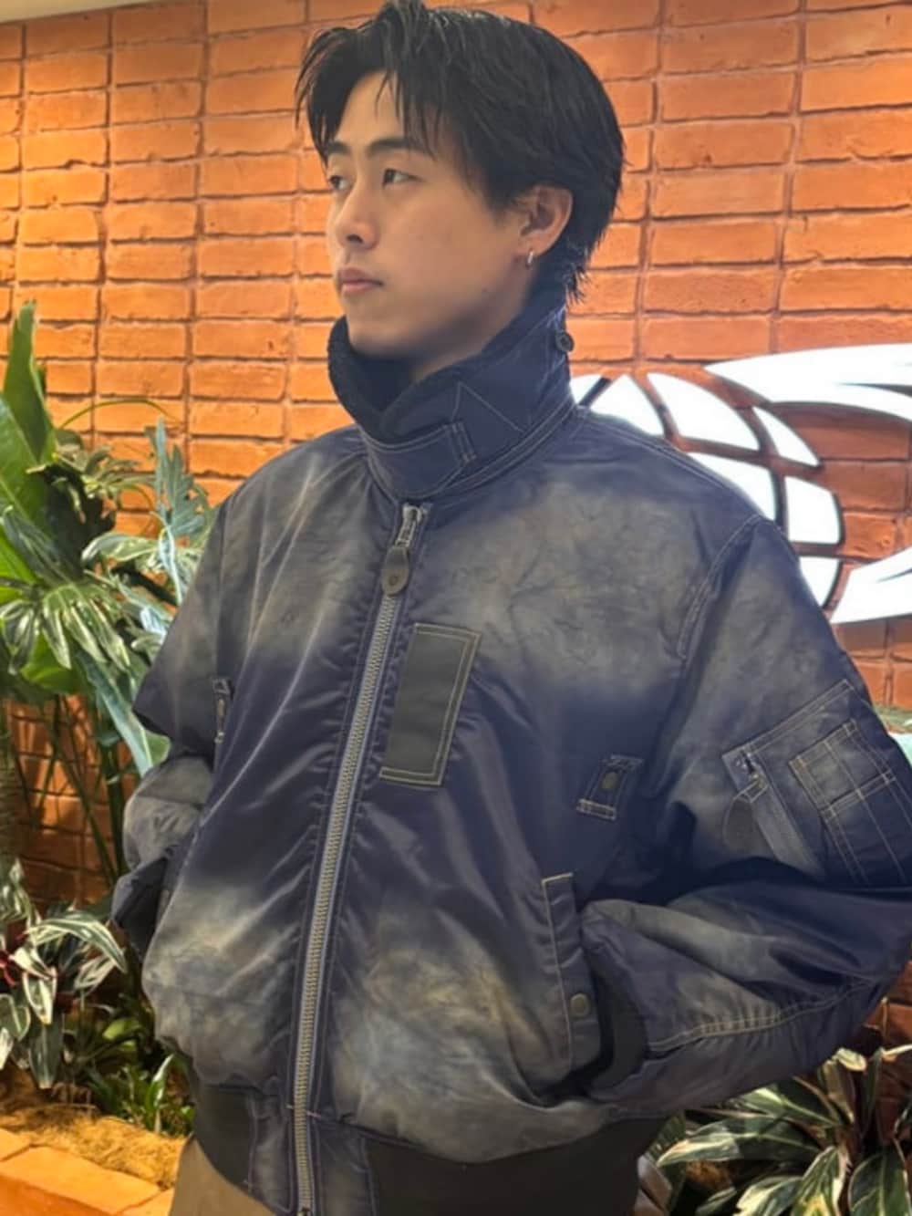 ブラック系のスニーカー、ブルー系のブルゾン、ベージュ系のチノパンツを着用したメンズの秋コーディネートの2枚目の写真