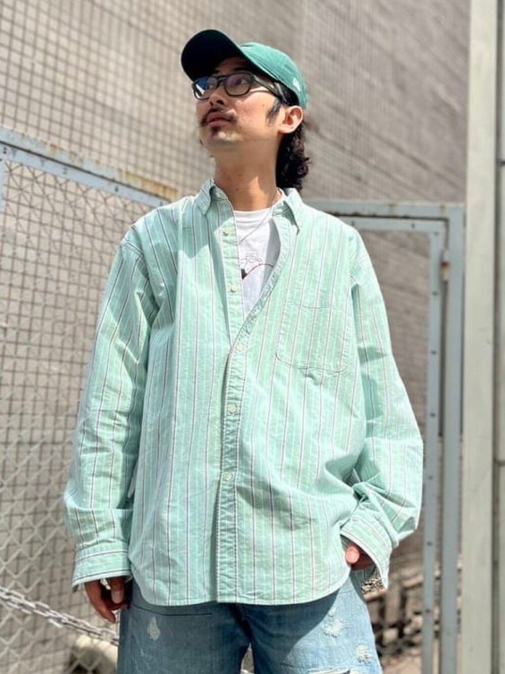 グリーン系のシャツ/ブラウス、グリーン系のキャップを着用したメンズの春コーディネートの2枚目の写真