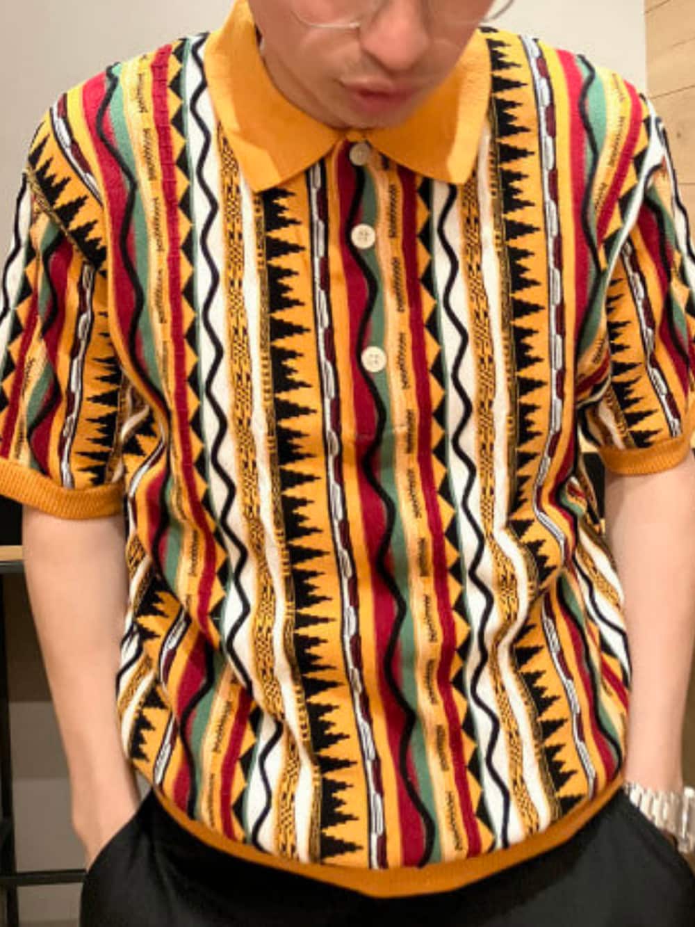 ベージュ系のその他パンツ、オレンジ系のポロシャツを着用したメンズの夏コーディネートの3枚目の写真