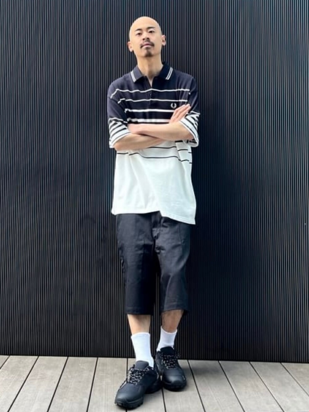 ベージュ系のその他パンツ、ブラック系のポロシャツを着用したメンズの春コーディネートの2枚目の写真