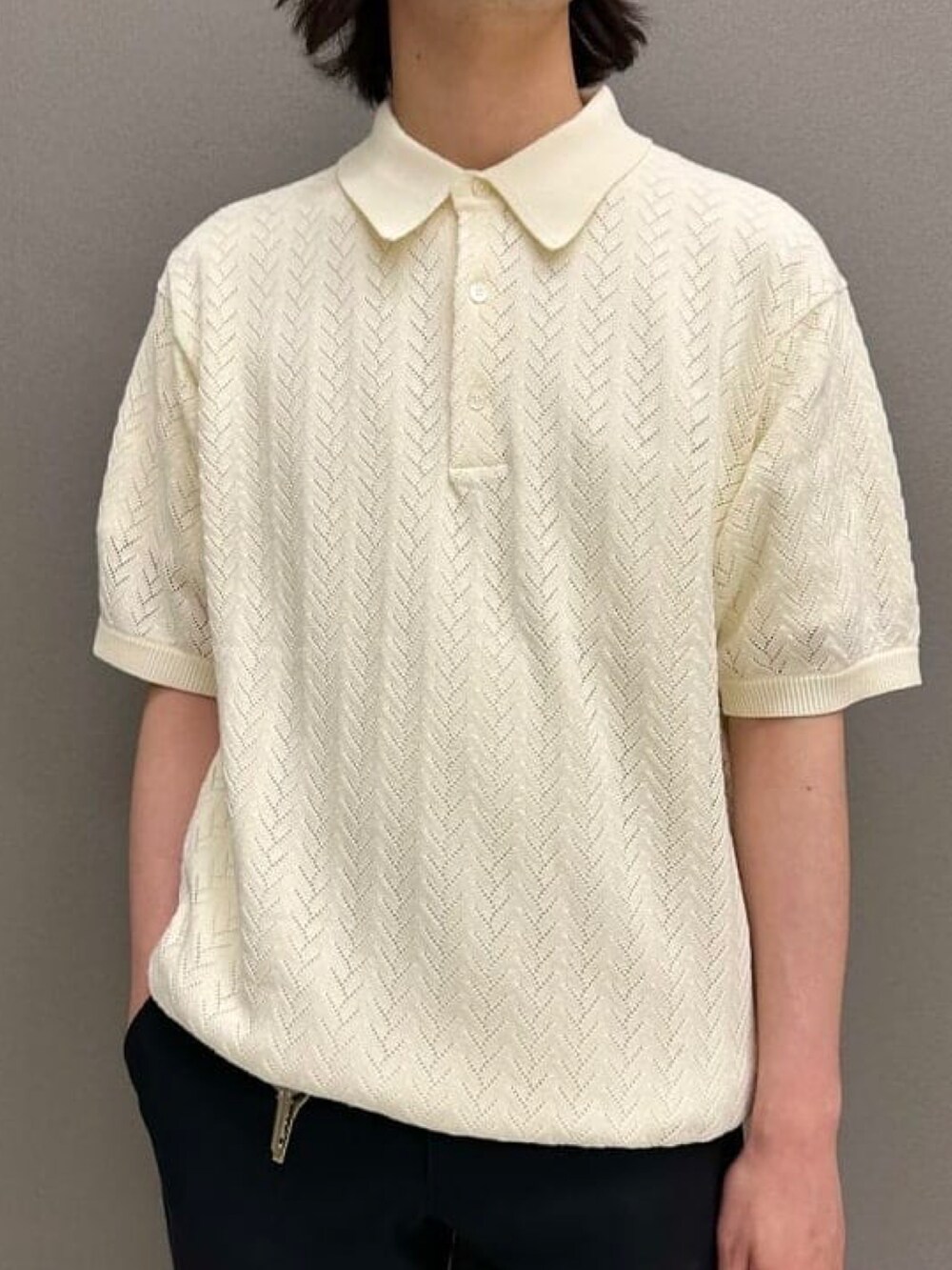 ホワイト系のポロシャツ、ブラック系のスラックス、ブラック系のスニーカーを着用したメンズの夏コーディネートの2枚目の写真