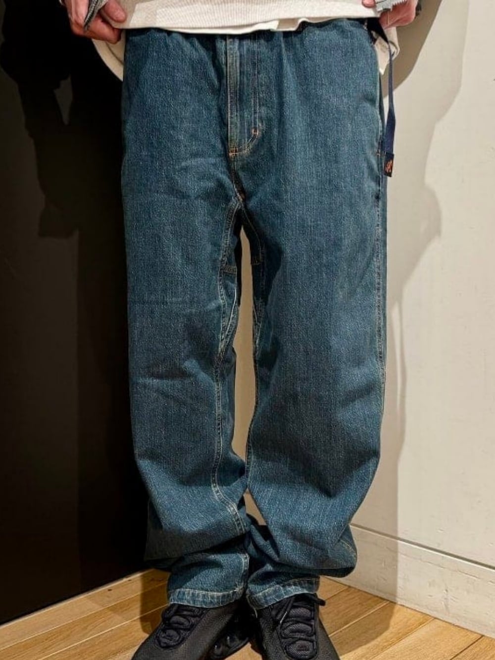 ブルー系のデニムパンツ、ブラック系のスニーカー、グレー系のスウェットを着用したメンズの春コーディネートの3枚目の写真