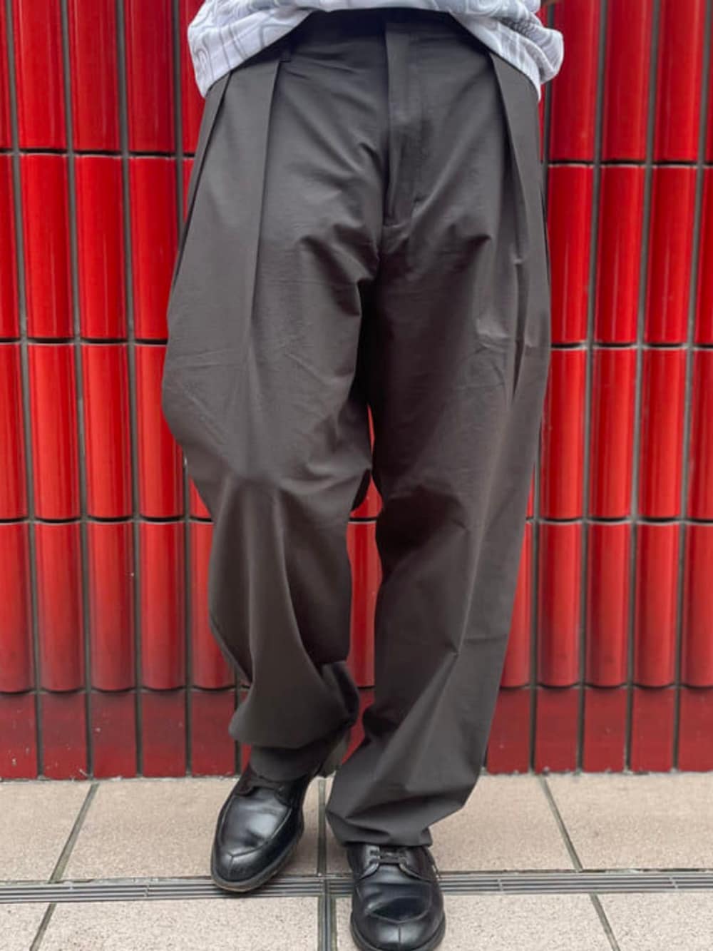 グレー系のスラックス、グレー系のTシャツ/カットソーを着用したメンズの夏コーディネートの3枚目の写真