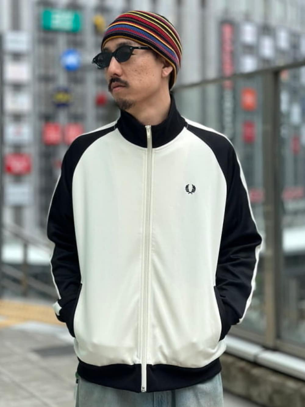 ホワイト系のジャージ、ブルー系のデニムパンツ、ブラック系のサングラスを着用したメンズの夏コーディネートの3枚目の写真
