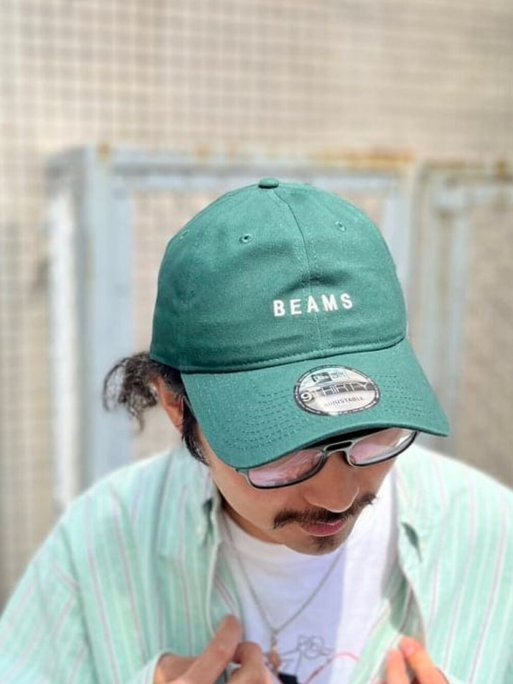 グリーン系のシャツ/ブラウス、グリーン系のキャップを着用したメンズの春コーディネートの3枚目の写真