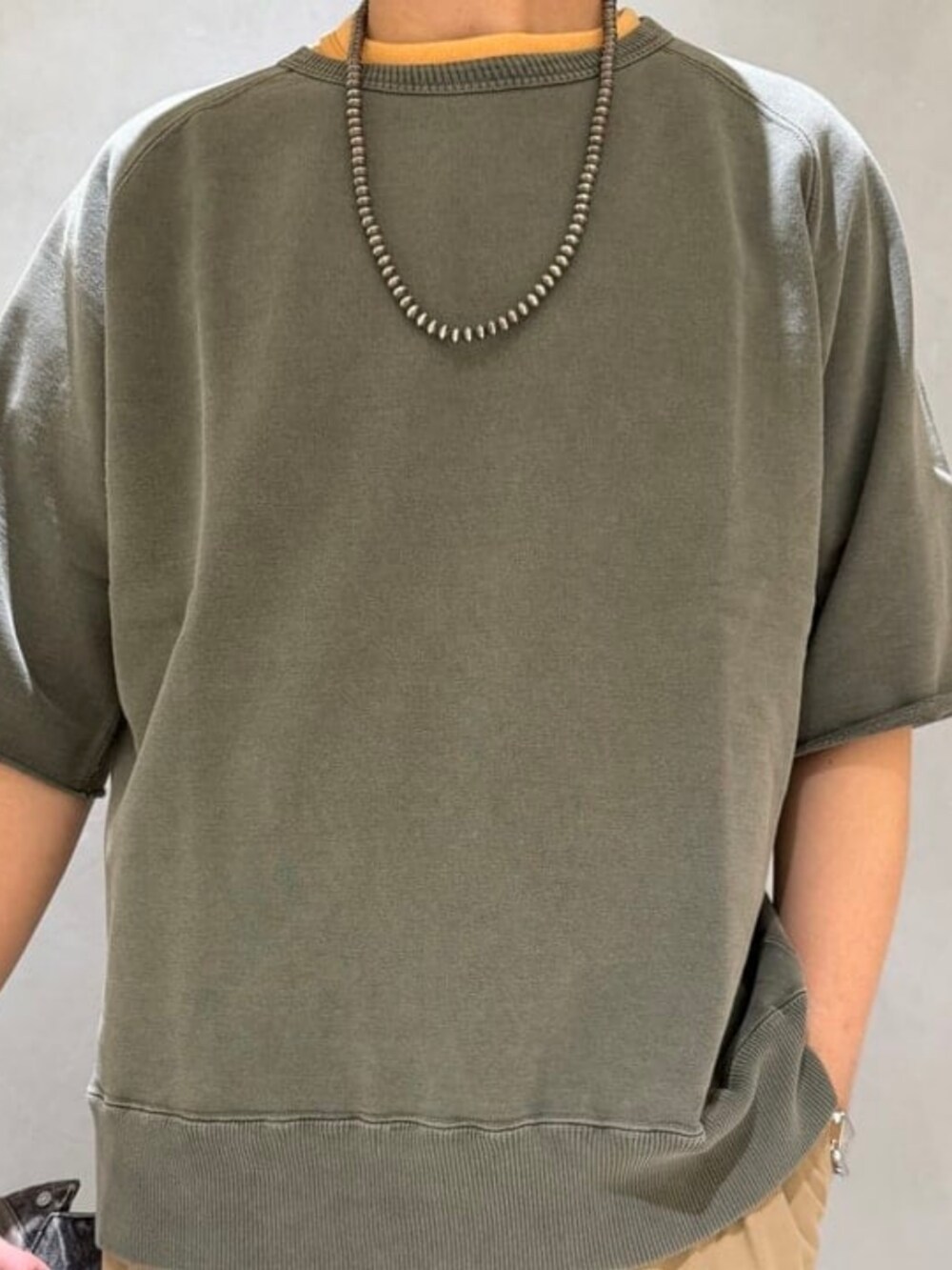 グリーン系のその他パンツ、グリーン系のスウェット、ブラック系のスニーカーを着用したメンズの春コーディネートの2枚目の写真