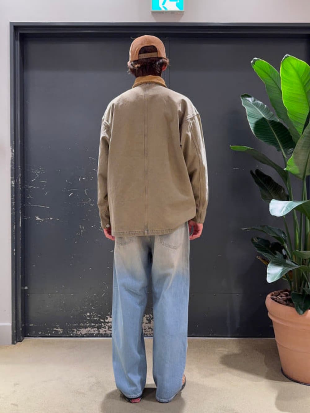 ブルー系のデニムパンツ、ベージュ系のブルゾンを着用したメンズの春コーディネートの2枚目の写真