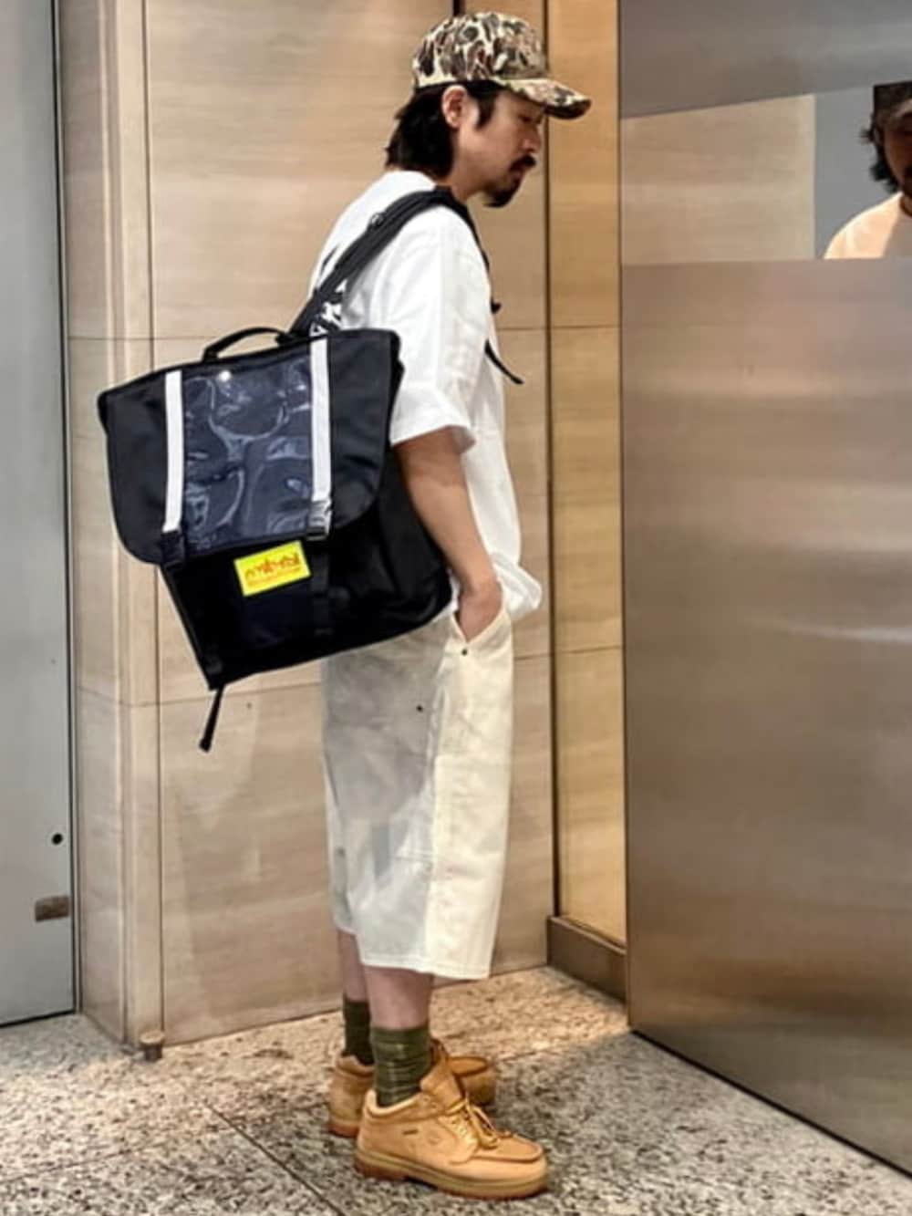 ベージュ系のその他パンツ、ホワイト系のTシャツ/カットソー、ブラック系のバックパック/リュックを着用したメンズの夏コーディネートの3枚目の写真