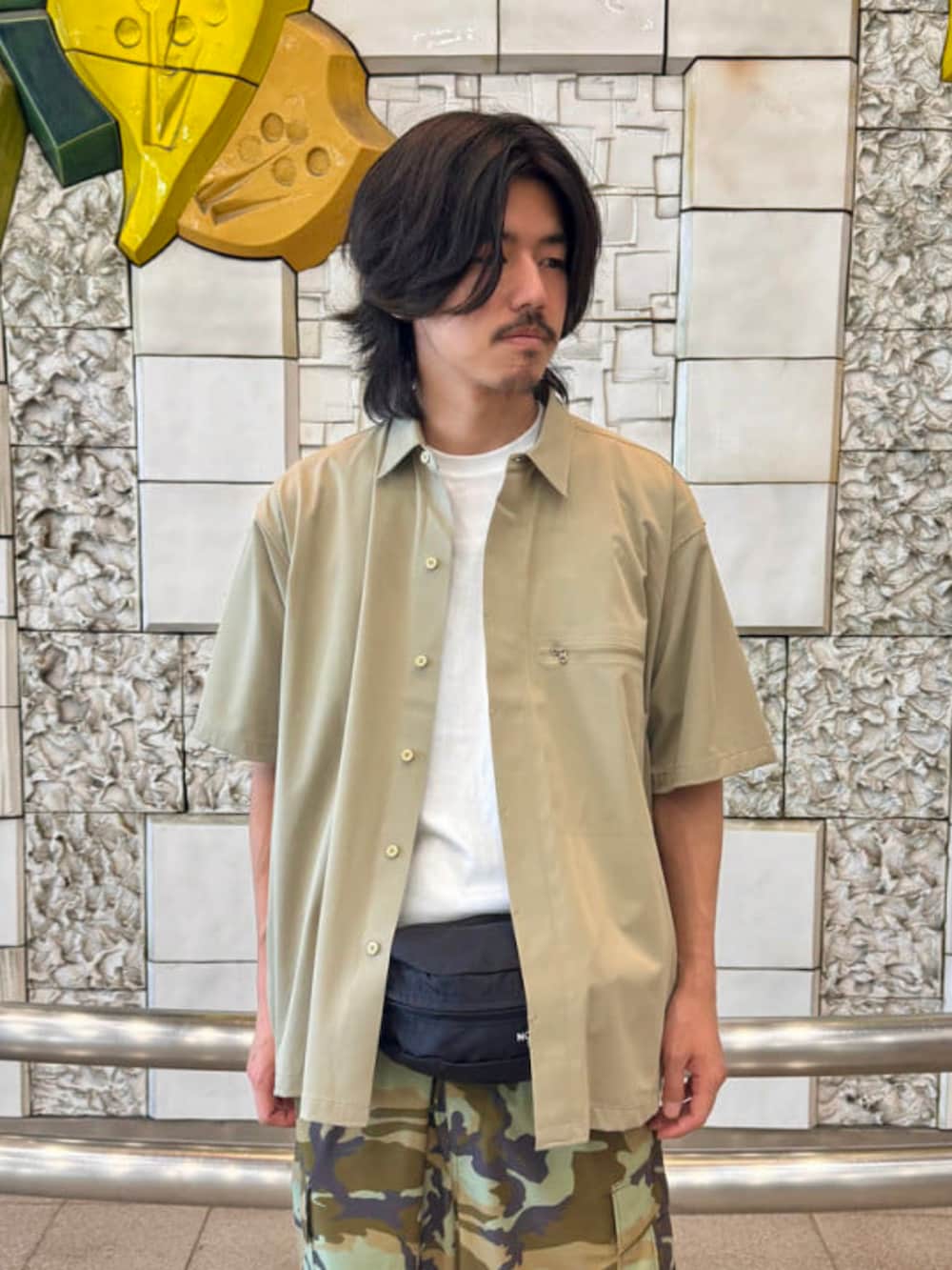 ブラック系のボディバッグ/ウエストポーチ、ホワイト系のTシャツ/カットソー、ベージュ系のシャツ/ブラウスを着用したメンズの春コーディネートの2枚目の写真