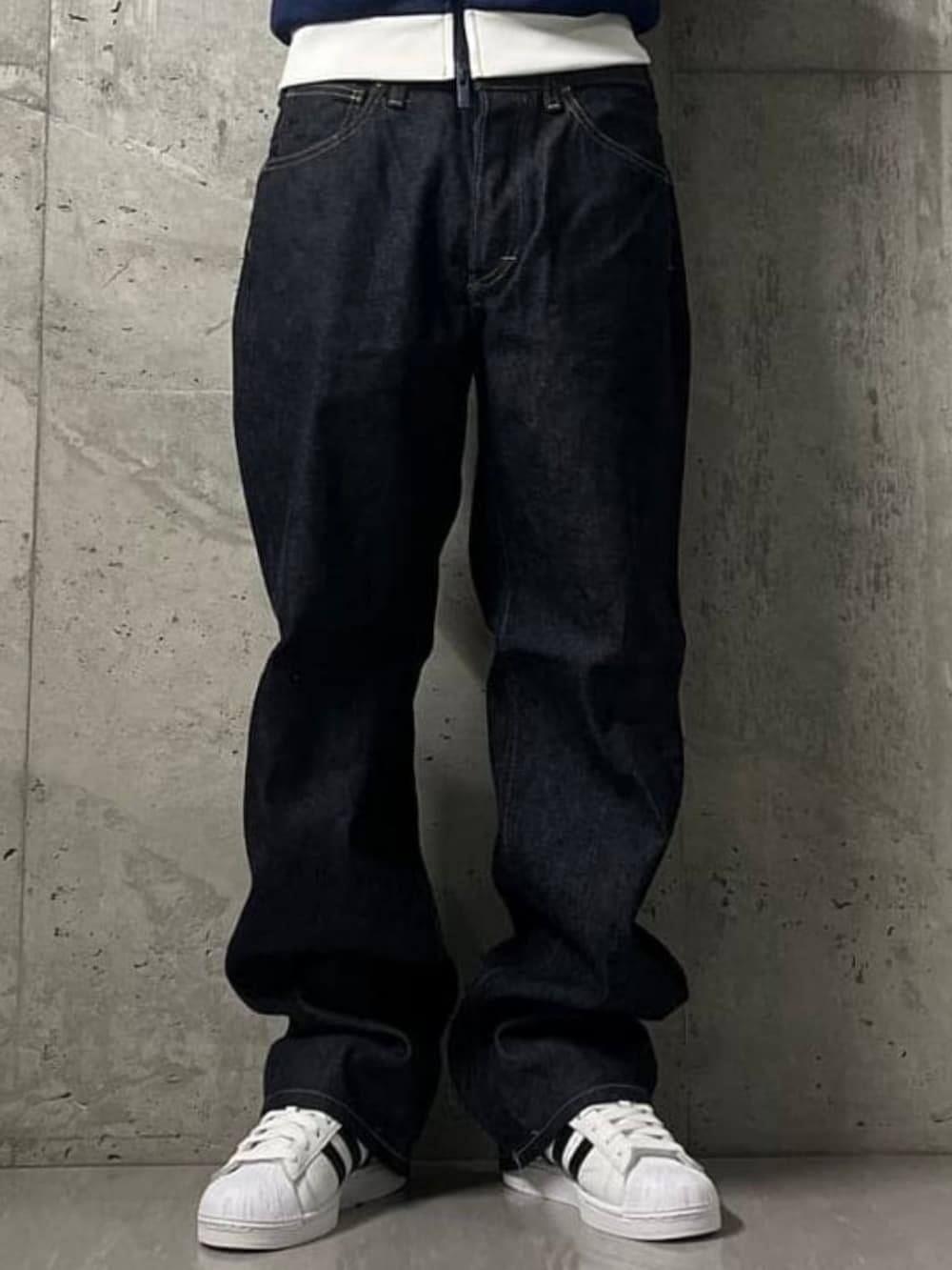 ブルー系のデニムパンツ、ブルー系のスウェット、ホワイト系のスニーカーを着用したメンズの秋コーディネートの7枚目の写真