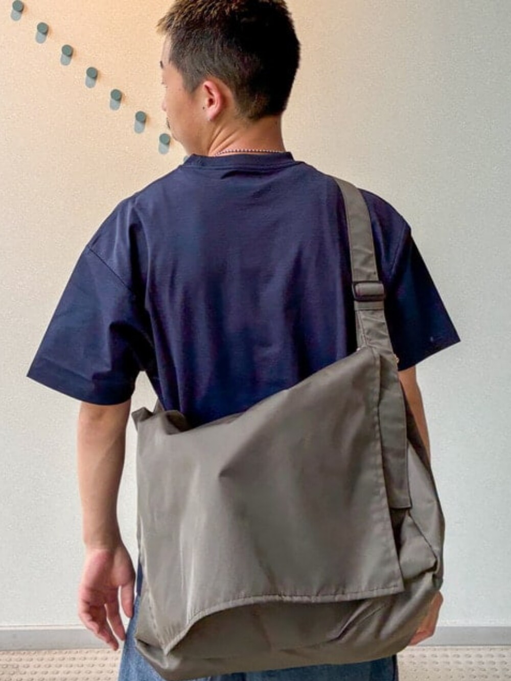 ブルー系のTシャツ/カットソー、ブルー系のスラックス、グリーン系のショルダーバッグを着用したメンズの夏コーディネートの3枚目の写真