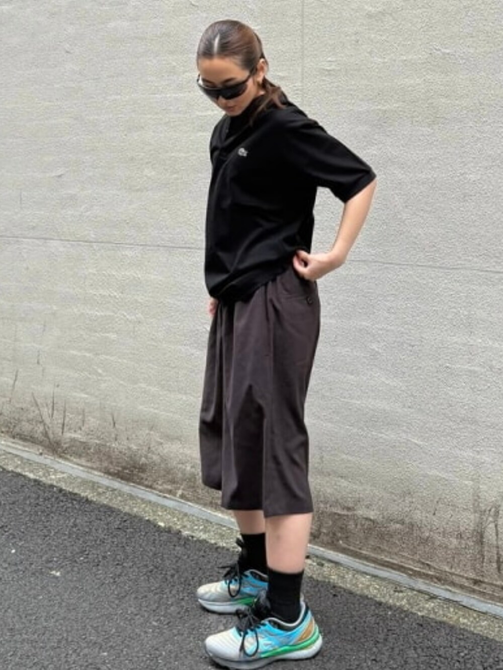 ブラック系のポロシャツ、ブラウン系のその他パンツを着用したレディースの春コーディネートの2枚目の写真