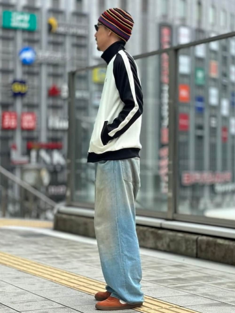 ホワイト系のジャージ、ブルー系のデニムパンツ、ブラック系のサングラスを着用したメンズの夏コーディネートの2枚目の写真