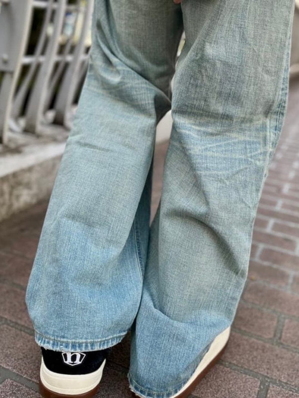 ブルー系のデニムパンツ、ブラック系のTシャツ/カットソー、ブラック系のスニーカーを着用したメンズの春コーディネートの5枚目の写真