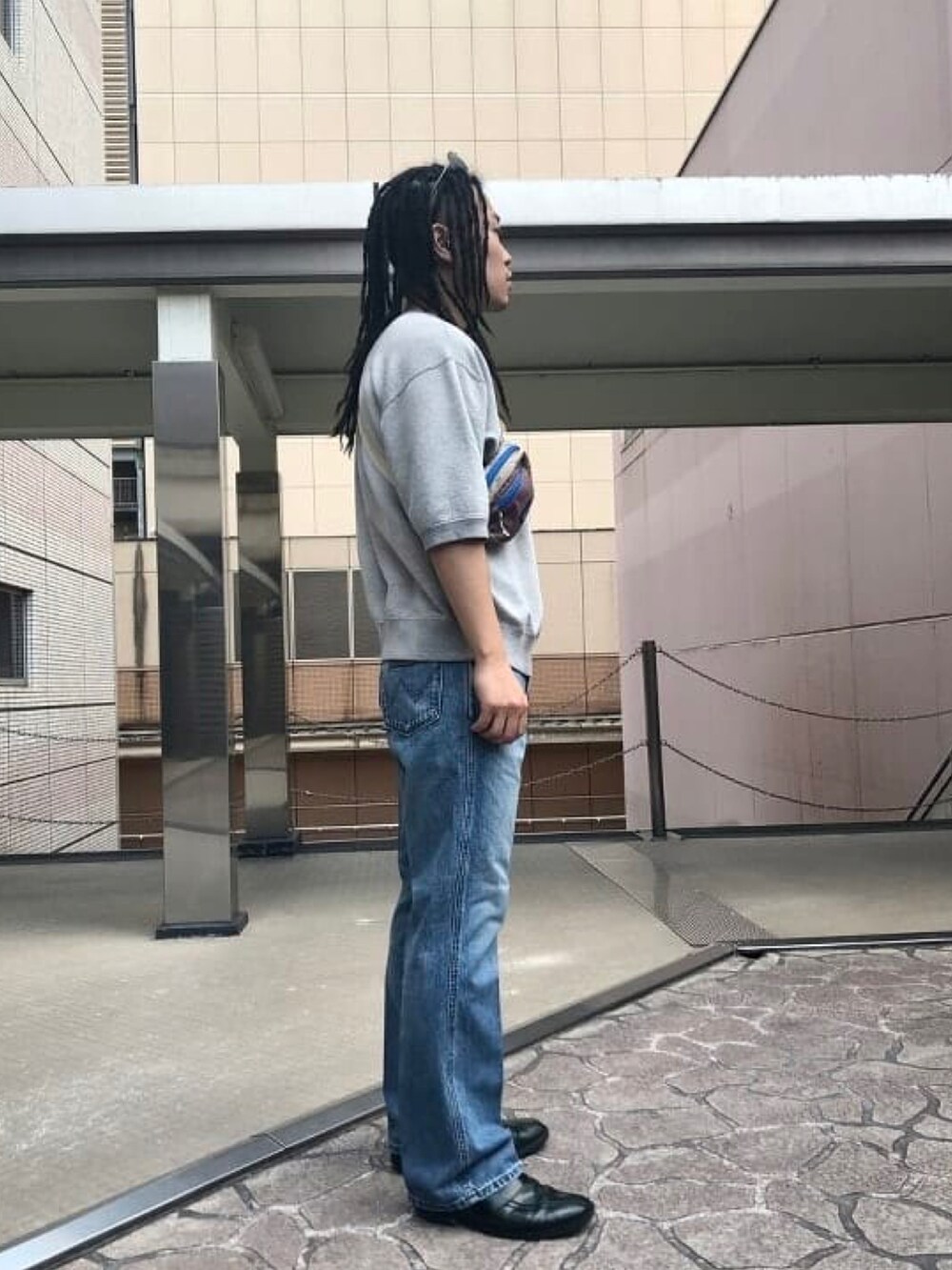 グレー系のスウェット、ブルー系のデニムパンツを着用したメンズの春コーディネートの2枚目の写真