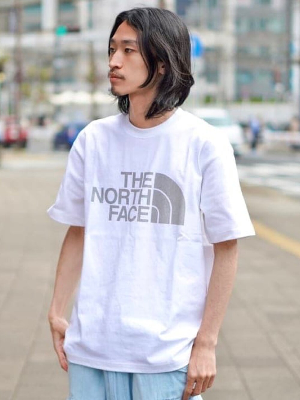 グリーン系のブルゾン、ホワイト系のTシャツ/カットソー、ブルー系のカーゴパンツを着用したメンズの春コーディネートの4枚目の写真