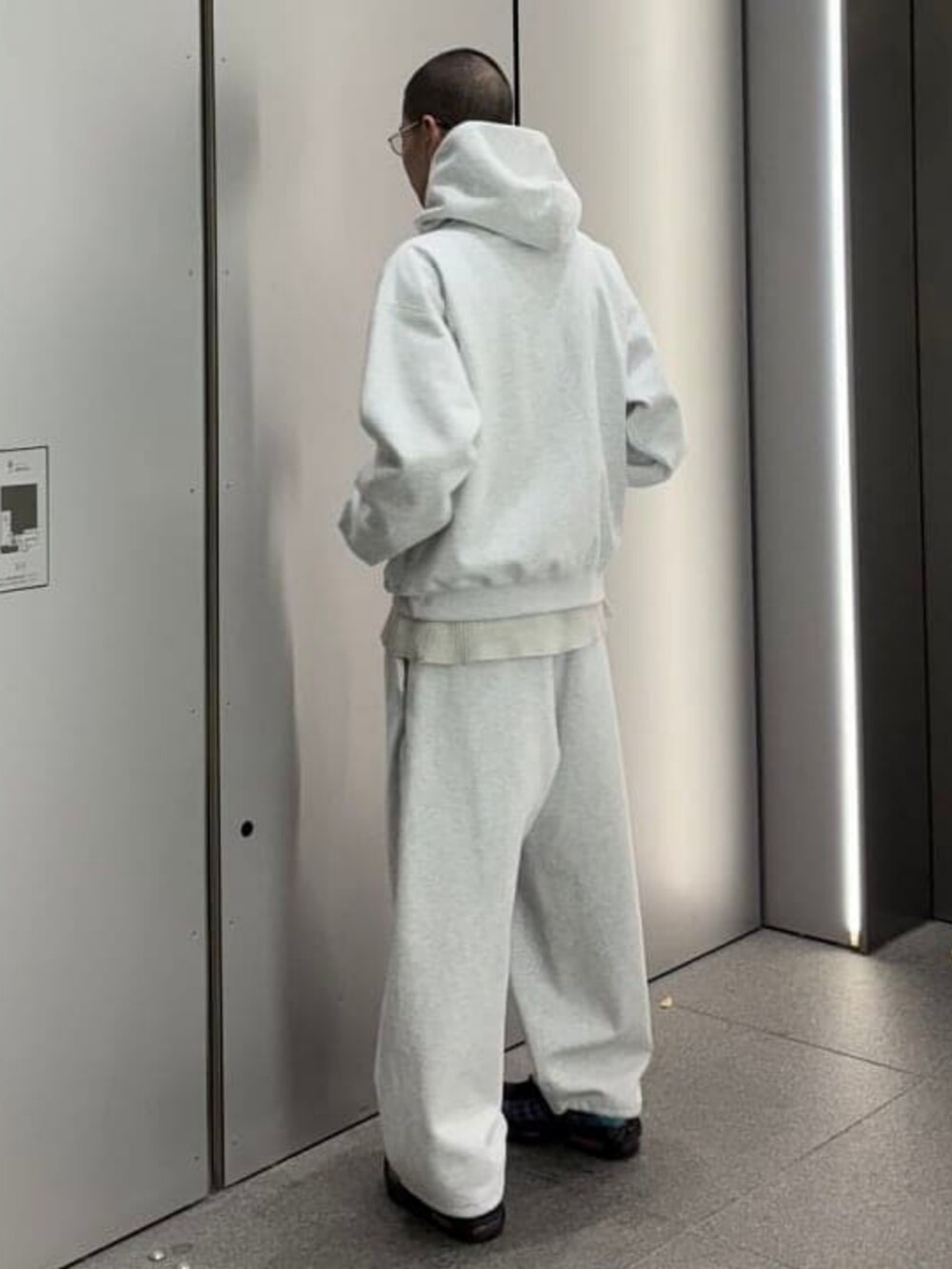 グレー系のパーカー、グレー系のスウェットパンツを着用したメンズの冬コーディネートの2枚目の写真