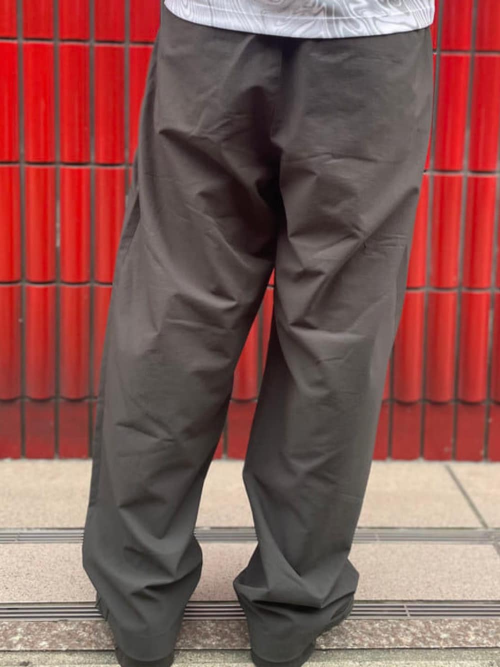 グレー系のスラックス、グレー系のTシャツ/カットソーを着用したメンズの夏コーディネートの4枚目の写真