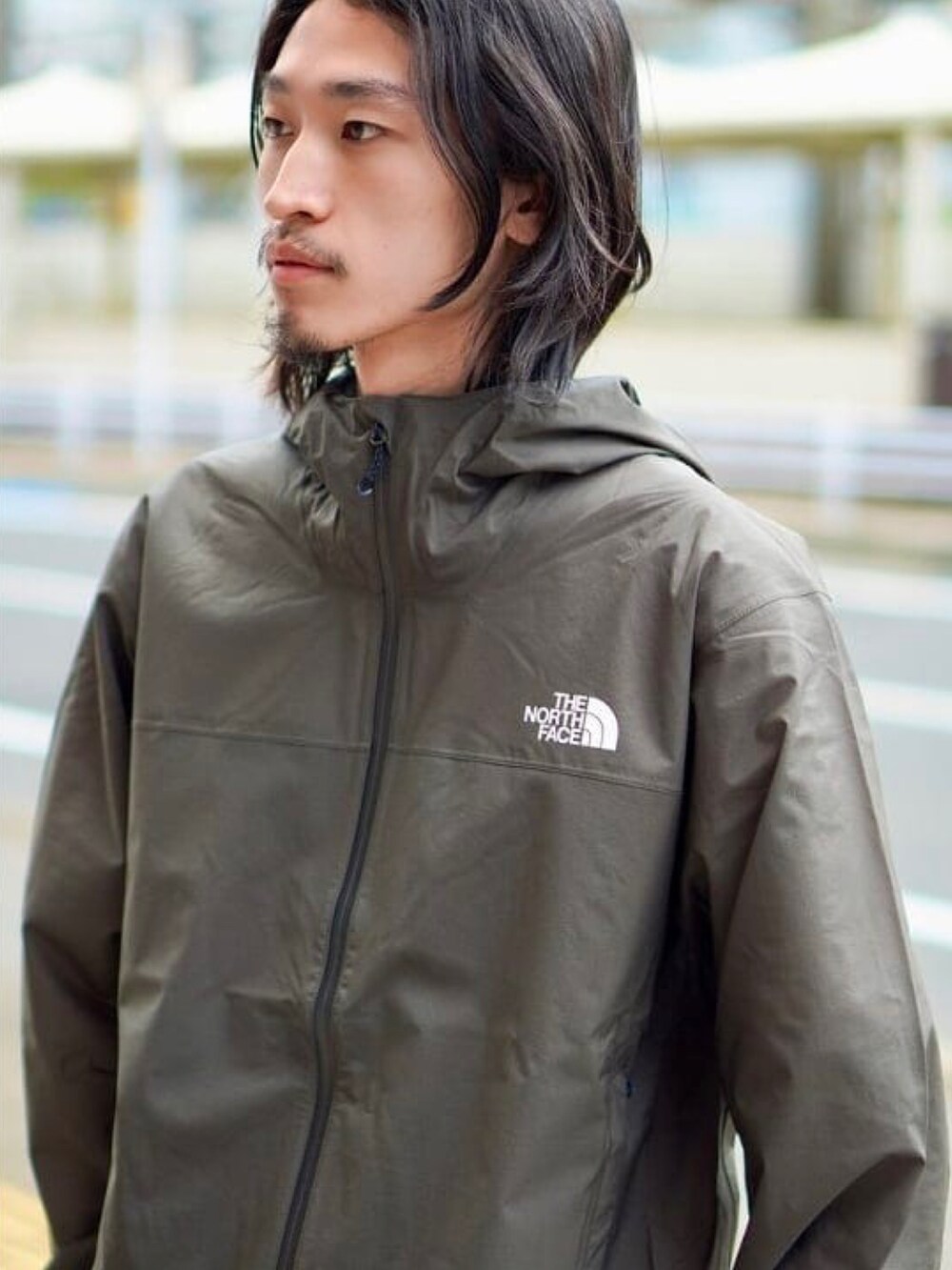 グリーン系のブルゾン、ホワイト系のTシャツ/カットソー、ブルー系のカーゴパンツを着用したメンズの春コーディネートの3枚目の写真