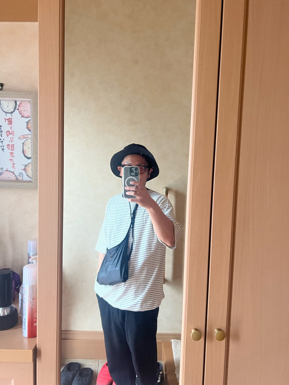 ホワイト系のTシャツ/カットソー、ブラック系のショルダーバッグ、ブラック系のスラックスを着用したメンズの夏コーディネートの2枚目の写真