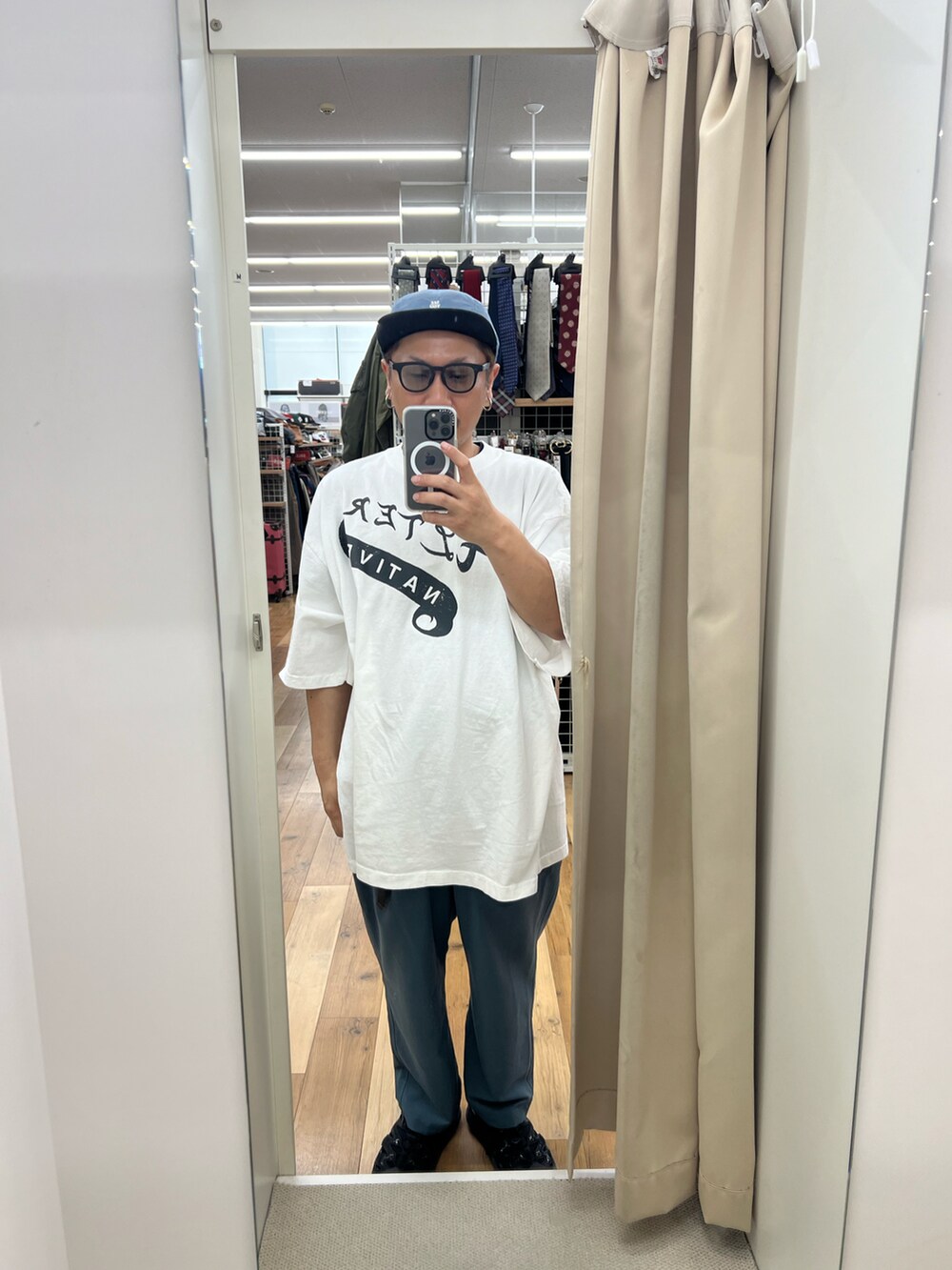 ホワイト系のTシャツ/カットソー、グリーン系のスラックス、ブラック系のサンダルを着用したメンズの夏コーディネートの2枚目の写真