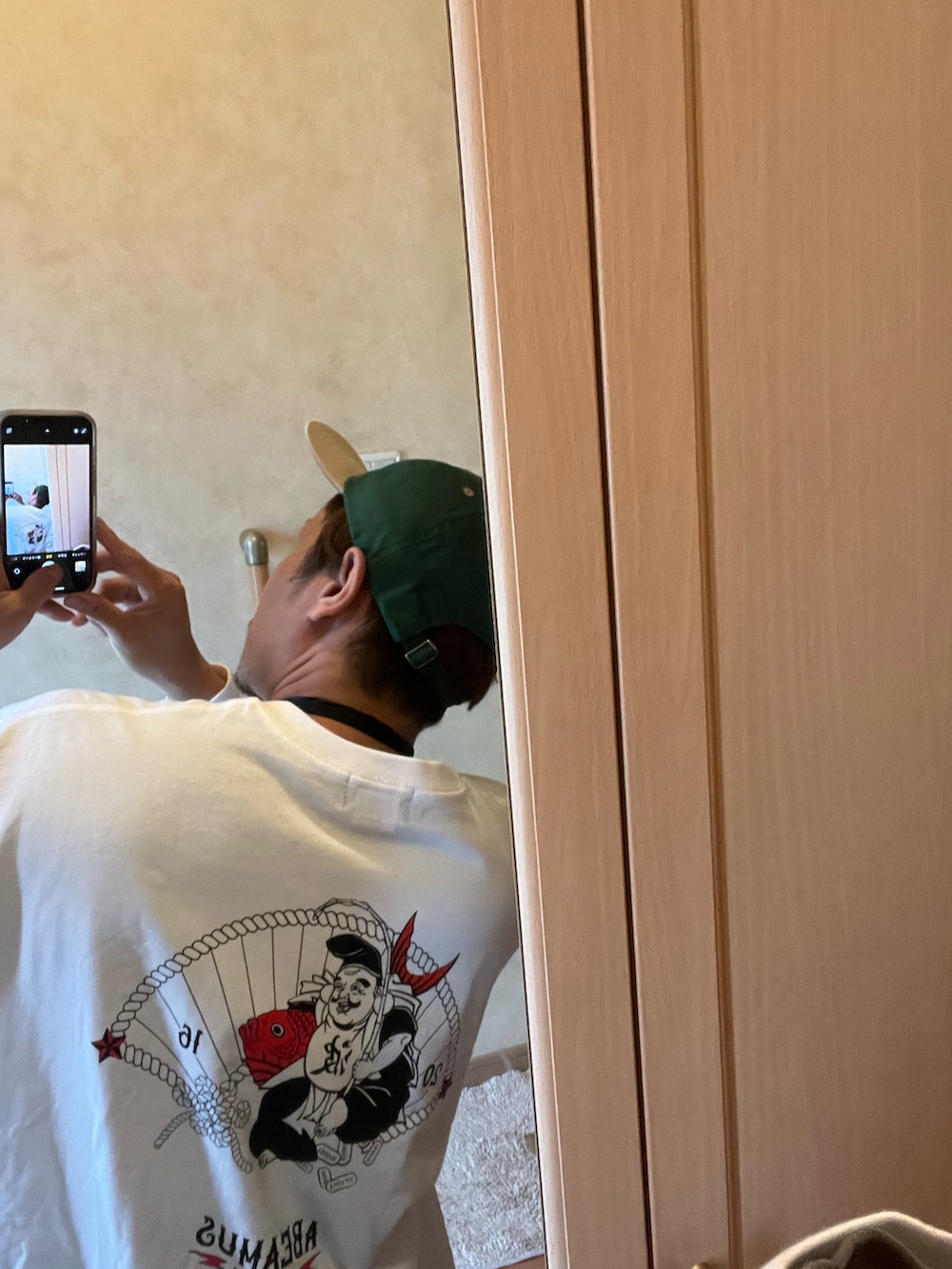 ホワイト系のTシャツ/カットソー、ブラック系のショルダーバッグ、グレー系のスウェットパンツを着用したメンズの秋コーディネートの2枚目の写真