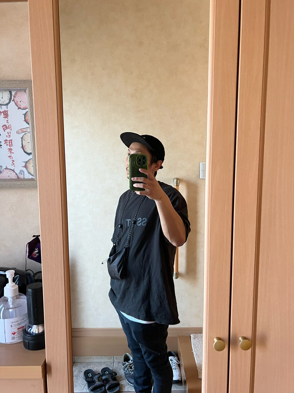 ブラック系のTシャツ/カットソー、ブラック系のデニムパンツ、ブラック系のスニーカーを着用したメンズの秋コーディネートの2枚目の写真