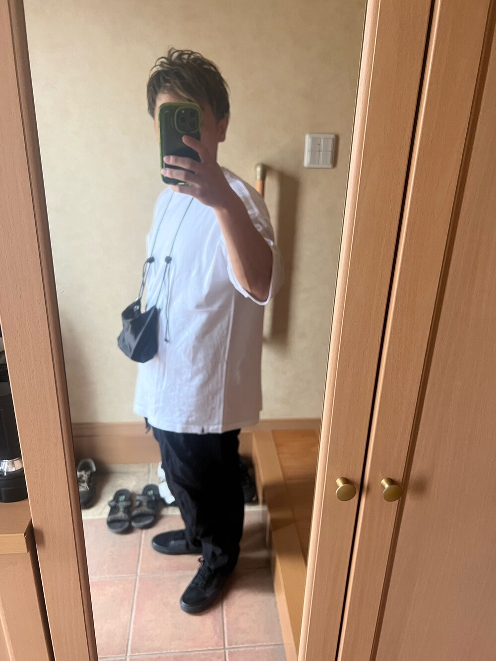 ホワイト系のTシャツ/カットソー、ブラック系のスラックス、ブラック系のスニーカーを着用したメンズの秋コーディネートの2枚目の写真