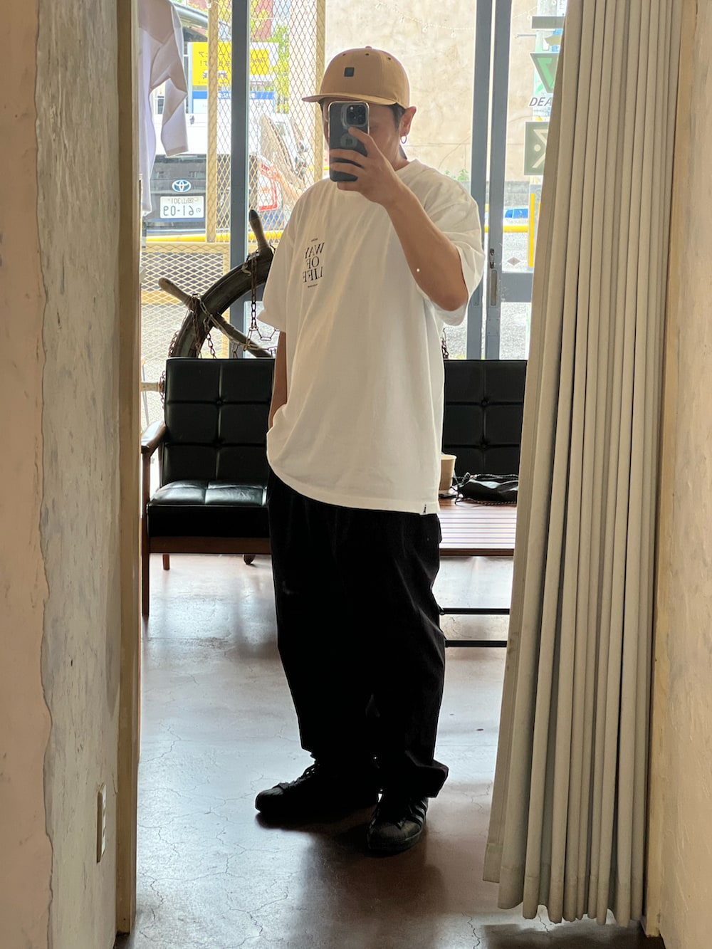 ホワイト系のTシャツ/カットソー、ブラック系のカーゴパンツ、ブラック系のスニーカーを着用したメンズの秋コーディネートの2枚目の写真