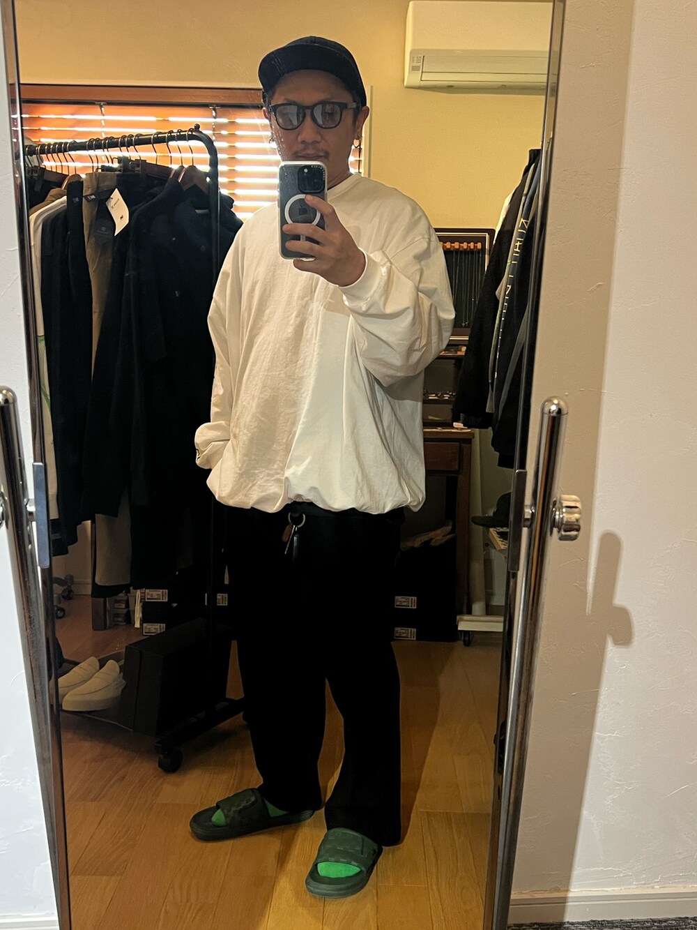 ホワイト系のTシャツ/カットソー、ブラック系のスラックス、ブラック系のキャップを着用したメンズの秋コーディネートの2枚目の写真