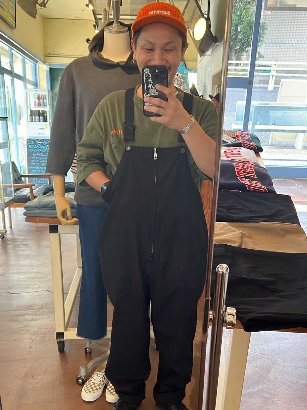 グリーン系のTシャツ/カットソー、ブラック系のサロペット/オーバーオール、ブラック系のスニーカーを着用したメンズの秋コーディネートの2枚目の写真