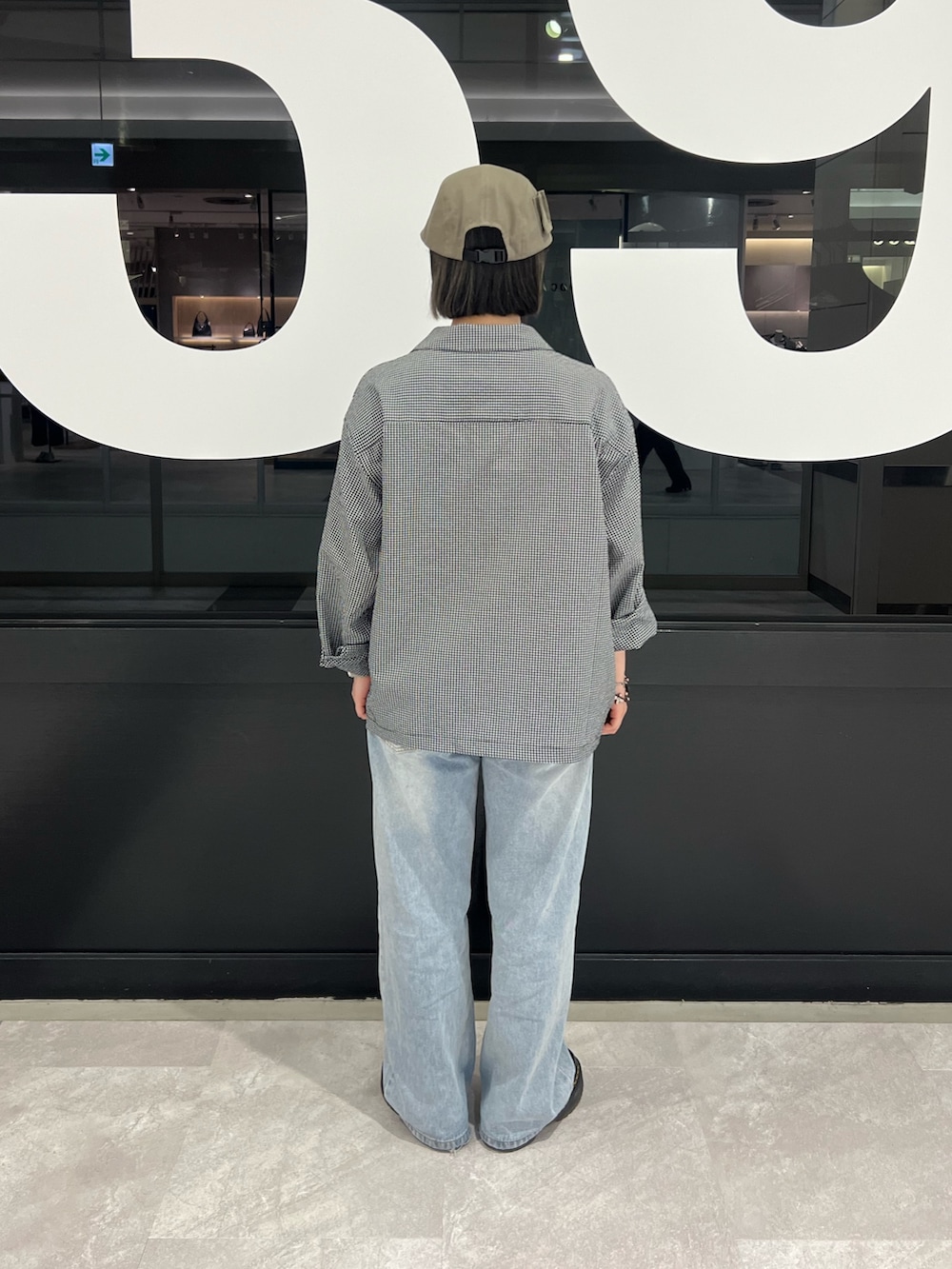 ブラック系のブルゾン、ブルー系のデニムパンツを着用したレディースの春コーディネートの3枚目の写真