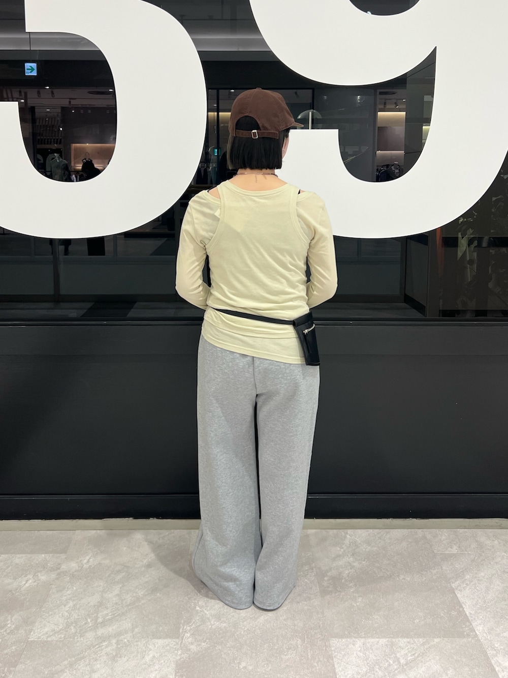 グリーン系のTシャツ/カットソー、グレー系のスウェットパンツ、ブラック系のボディバッグ/ウエストポーチを着用したレディースの春コーディネートの3枚目の写真