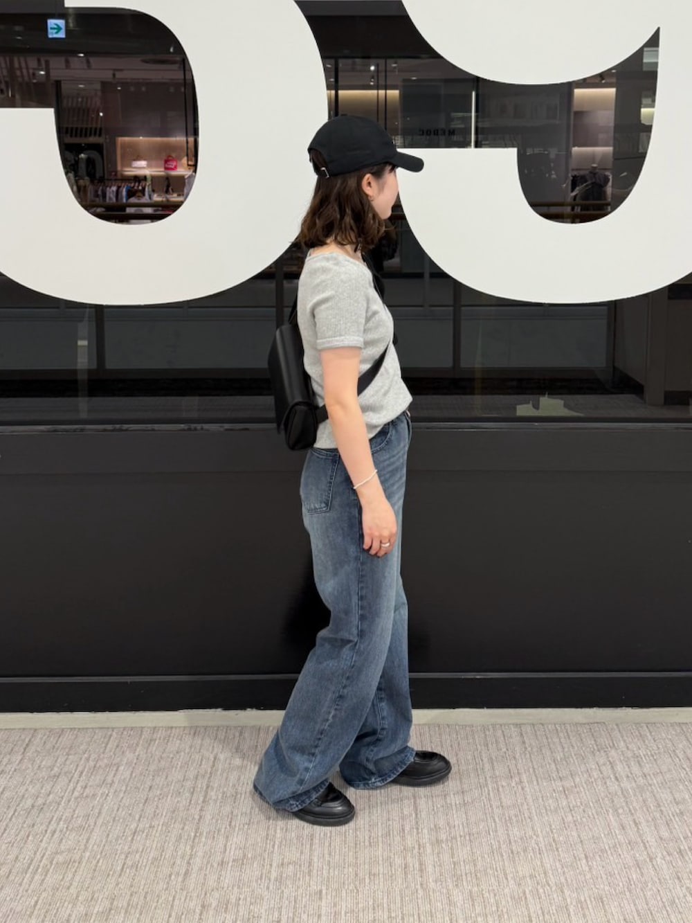 ブルー系のデニムパンツ、グレー系のTシャツ/カットソー、ブラック系のボディバッグ/ウエストポーチを着用したレディースの夏コーディネートの2枚目の写真