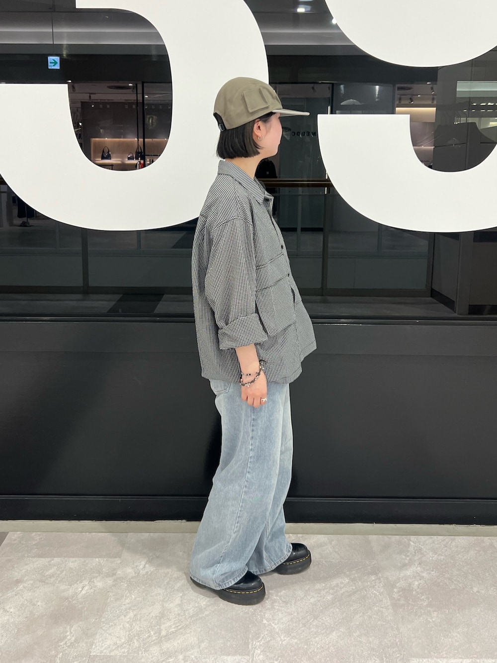 ブラック系のブルゾン、ブルー系のデニムパンツを着用したレディースの春コーディネートの2枚目の写真