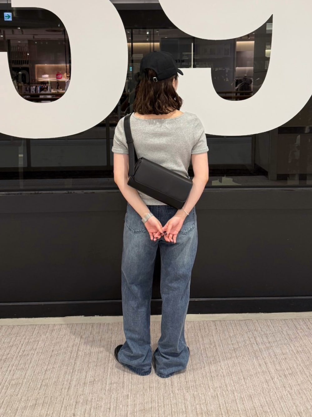 ブルー系のデニムパンツ、グレー系のTシャツ/カットソー、ブラック系のボディバッグ/ウエストポーチを着用したレディースの夏コーディネートの3枚目の写真