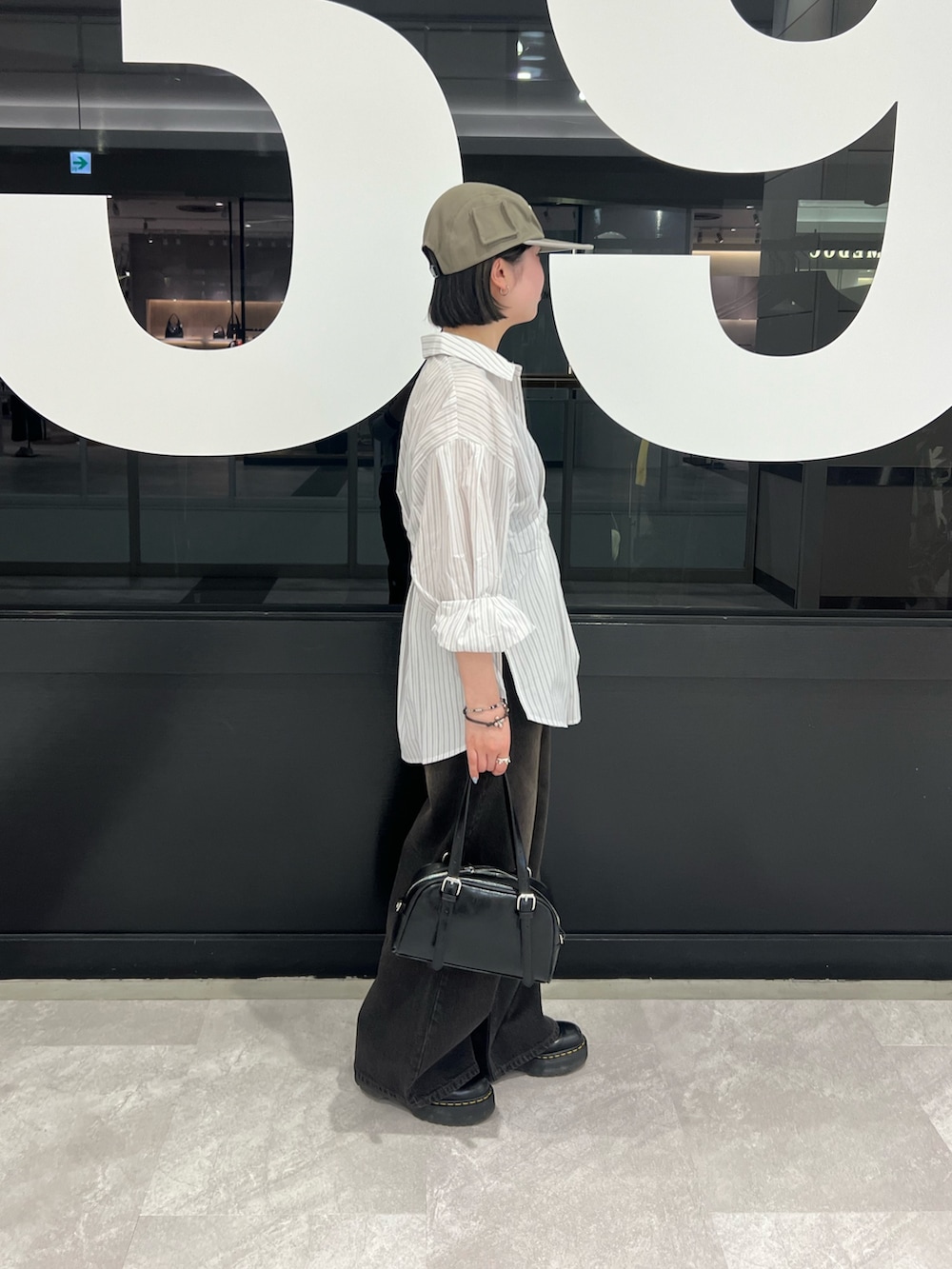 ホワイト系のシャツ/ブラウス、ブラック系のデニムパンツ、ブラック系のボストンバッグを着用したレディースの春コーディネートの2枚目の写真