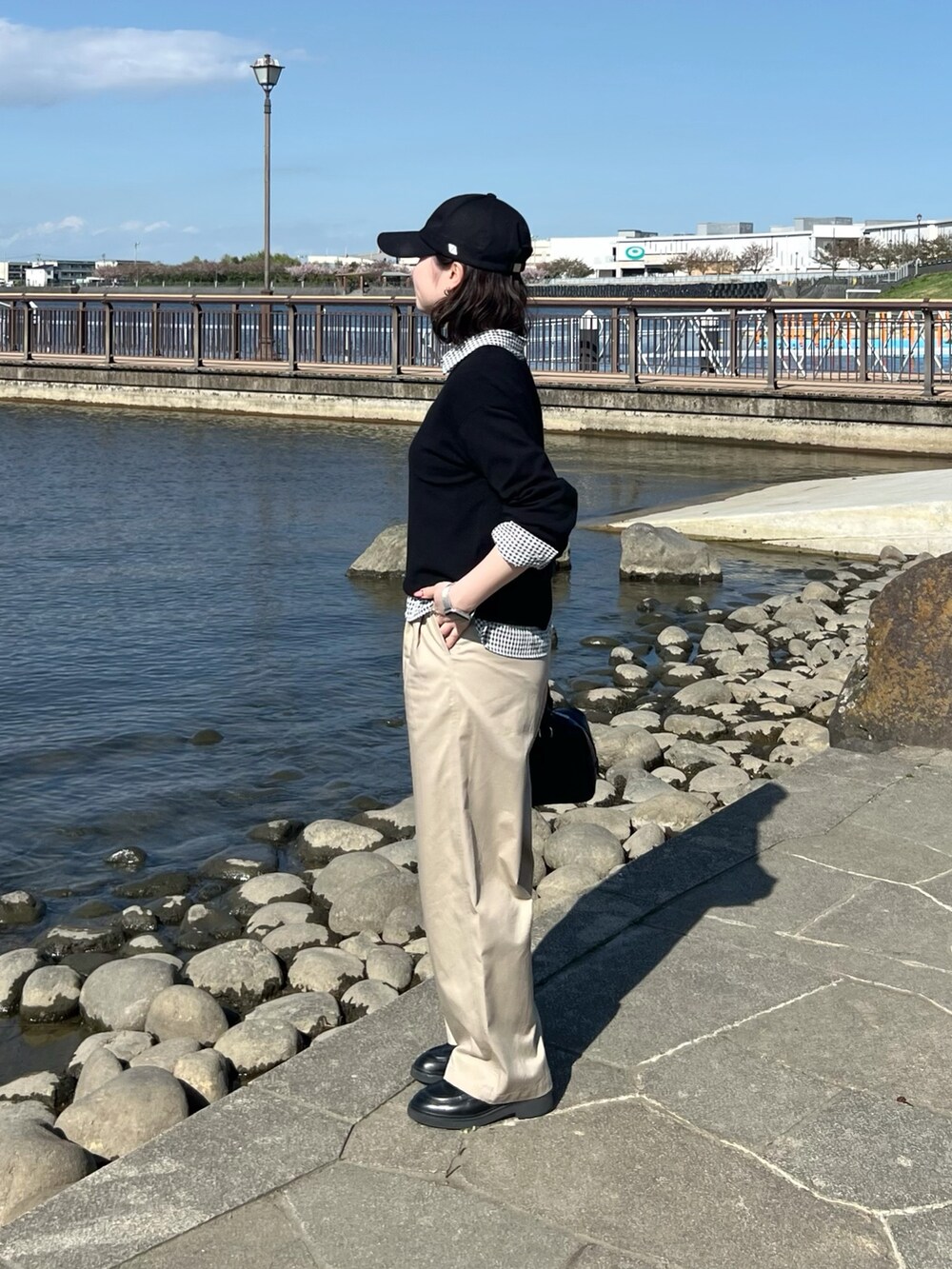 ブラック系のTシャツ/カットソー、ブラック系のシャツ/ブラウス、ベージュ系のチノパンツを着用したレディースの春コーディネートの2枚目の写真