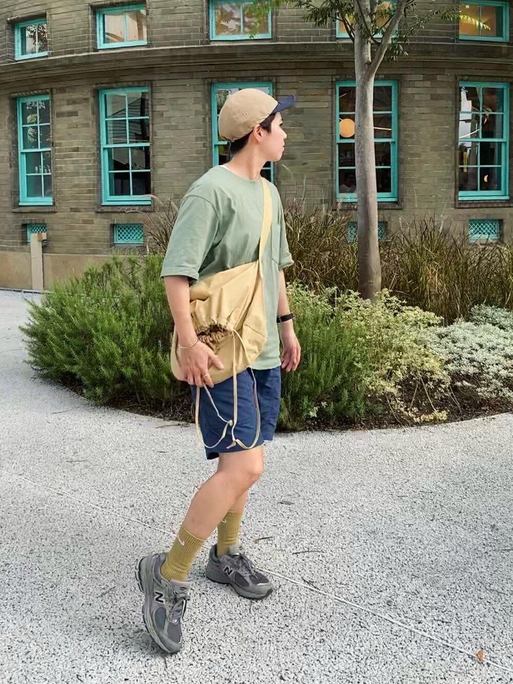 ベージュ系のバッグ、グリーン系のシューズ、ベージュ系の帽子を着用したレディースの夏コーディネートの3枚目の写真