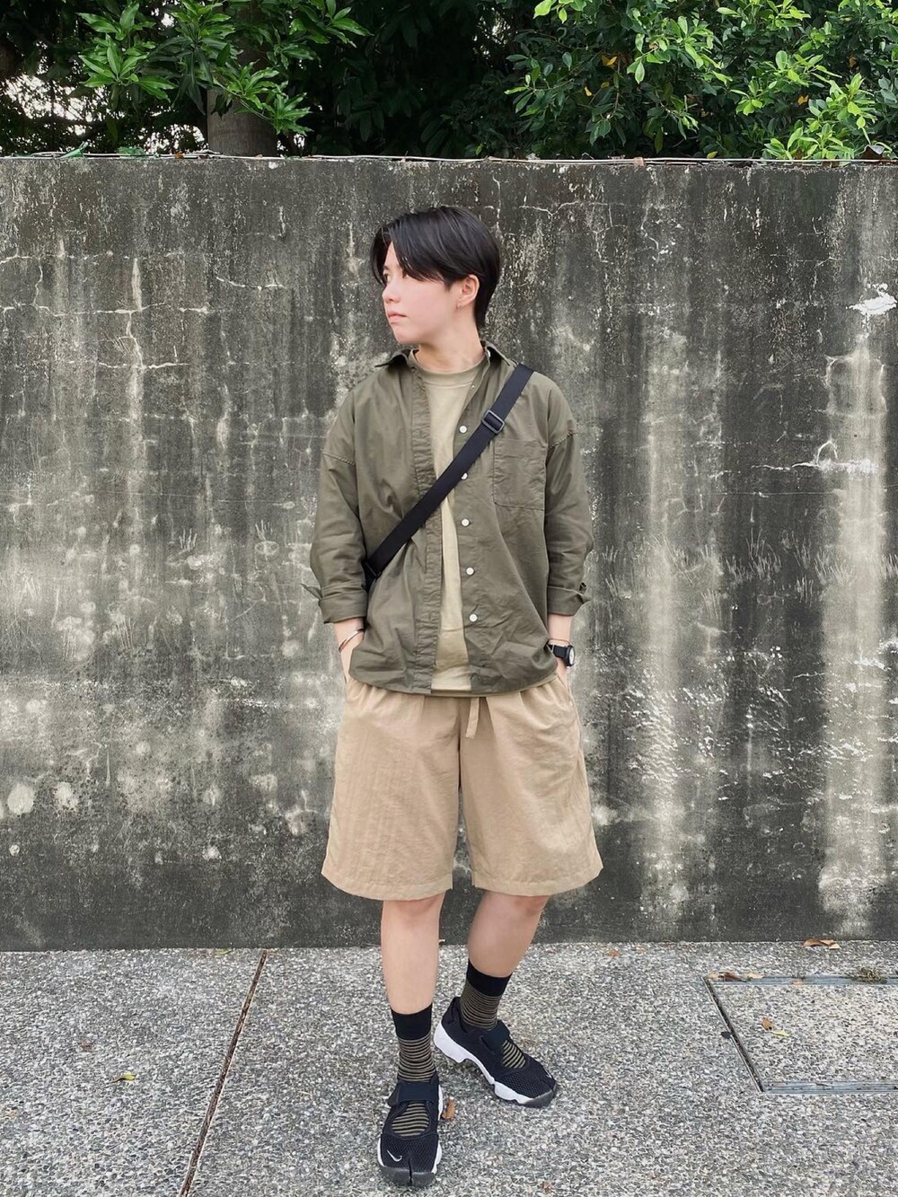 ブラック系のスニーカー、ベージュ系のパンツを着用したレディースの夏コーディネートの2枚目の写真