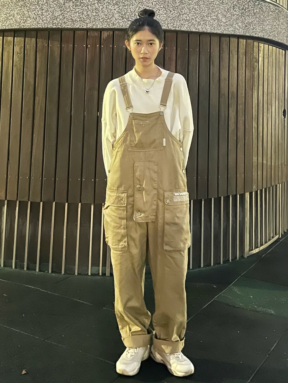 ブルー系のトップス、ベージュ系のオールインワン・サロペット、ホワイト系のスニーカーを着用したレディースの冬コーディネートの2枚目の写真