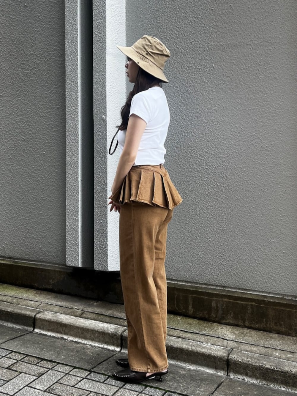 ブラウン系のサンダル、ブラウン系のデニムパンツ、ホワイト系のTシャツ/カットソーを着用したレディースの夏コーディネートの2枚目の写真