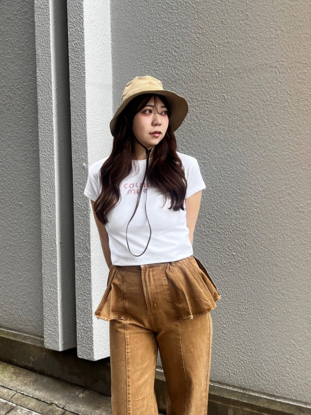 ブラウン系のサンダル、ブラウン系のデニムパンツ、ホワイト系のTシャツ/カットソーを着用したレディースの夏コーディネートの4枚目の写真