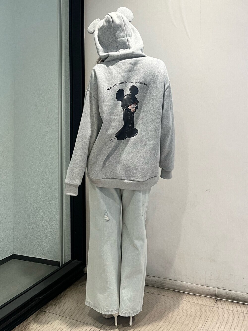 ホワイト系のパンプス、グレー系のスウェット、ブルー系のデニムパンツを着用したレディースの秋コーディネートの3枚目の写真